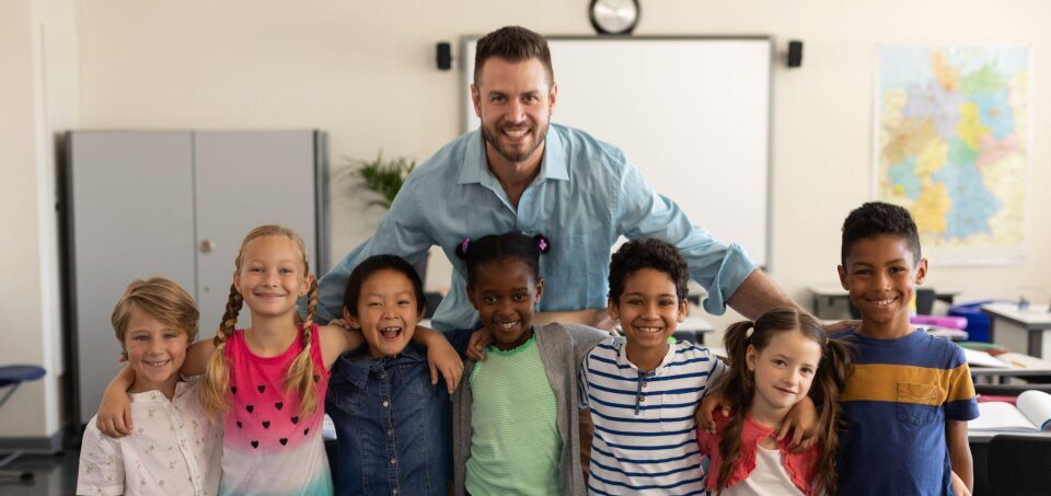 Elementary Classroom of diverse students and teacher smiling
